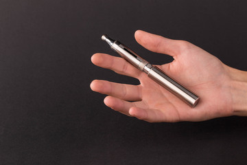 Hand holding electronic cigarette.