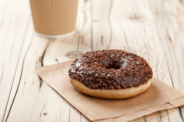Donut and paper cup on wooden table