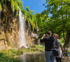 Tourists photographed a beautiful waterfall.