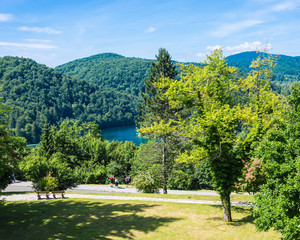 Landscape of Plitvice Lakes with tourists. Sunny day.