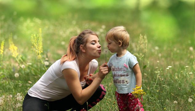 Młoda mama z c&oacute;reczką na łące.