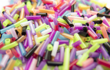 Background of colorful small elements, tubes, beads