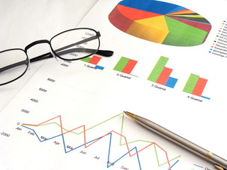 Bilanz und Analyse mit Kugelschreiber und Brille 