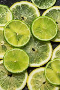Sliced lemon and lime on a dark background, top view, selective