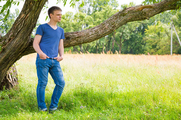 Handsome young man under a tree