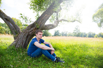 Handsome young man under a tree