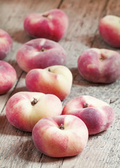 Flat pink peach on an old wooden background, selective focus