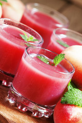 Freshly squeezed pink peach juice in glasses, selective focus