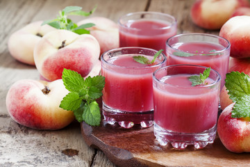 Freshly squeezed pink peach juice in glasses, selective focus