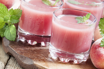 Freshly squeezed pink peach juice in glasses, selective focus