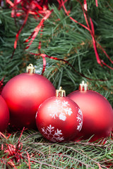 four red Christmas balls and Xmas tree background