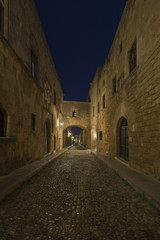 Fototapeta na wymiar Medieval Avenue of the Knights at night, a cobblestone street in Rhodes Citadel , Greece