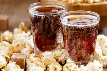 Caramel popcorn and cola in a glass, selective focus