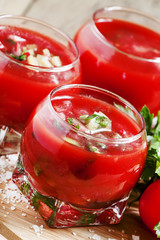 Tomato soup with vegetables in a round glass bowl, selective foc