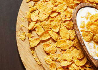 Healthy breakfast: cornflakes with milk in a wooden bowl in the