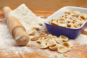 Fresh italian pasta orecchiette in blue porcelain, handmade with whole wheat flour
