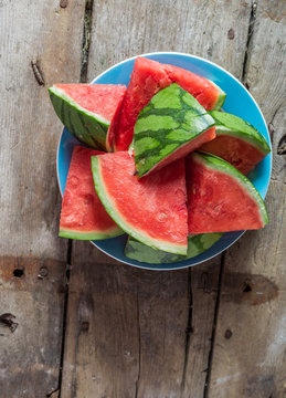 Pieces of watermelon on a plate on a wooden table