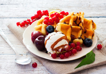 Belgium waffles with chocolate sauce, ice cream and berries