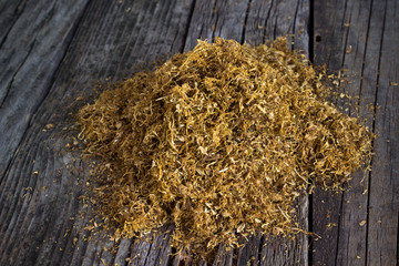 Pile of dried tobacco on wooden background