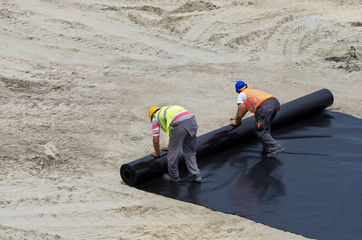 Workers unrolling foil