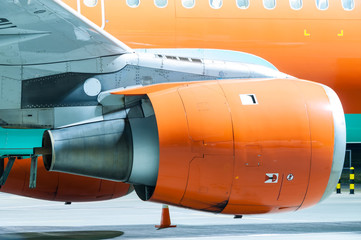 Engine of the airplane painted in orange. Close-up. Heavy