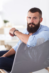 Fototapeta premium Young businessman sitting on chair in office