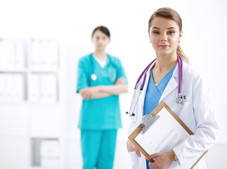 Fototapeta premium Woman doctor standing with folder at hospital