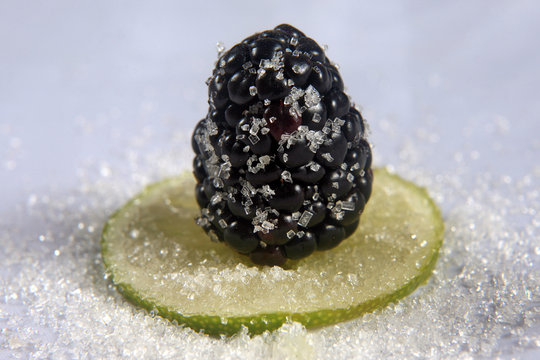 blackberry sugar coated lies on the slice of lemon