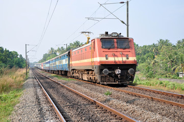 A passenger train being hauled by an electric locomotive in Kerala, India.