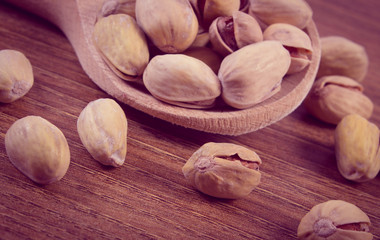 Vintage photo, Pistachio nuts with spoon on wooden table, healthy eating