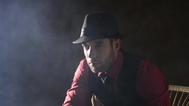Man in a hat with fog rising around him
