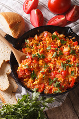 Turkish Menemen omelet close-up in a frying pan. vertical top view
