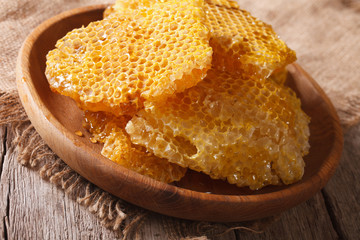 Fresh honey combs on a wooden plate close-up. horizontal 
