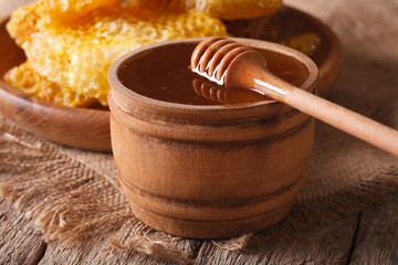 Fresh honey in a wooden bowl and honeycomb, horizontal
