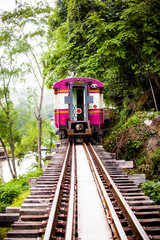 Trains run on tracks through the woods and cliffs 