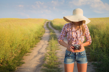 Outdoor portrait of young  attractive woman with retro camera