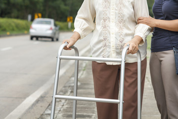 senior woman using a walker cross street