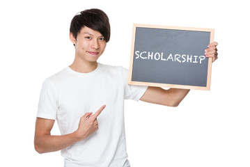 Man hold with chalkboard showing a word scholarship