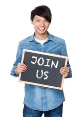 Asian young man with chalkboard showing a phrases of join us