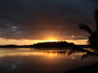 Fiji, tramonto su un atollo con palme ed oceano pacifico