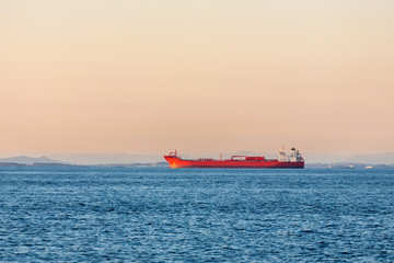 Fototapeta premium Freight ship on the ocean at sunset