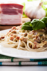 Spaghetti carbonara with bacon and basil