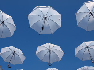 Fototapeta na wymiar White umbrelas over blue sky