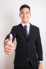 Portrait of the smiling man showing thumb up isolated on white b