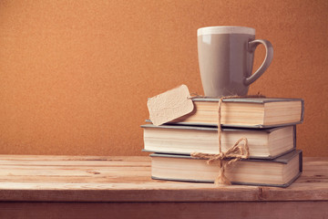 Old vintage books with cup and price tag on wooden table. Back to school concept