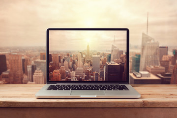 Laptop computer over New York city skyline. Retro filter effect - obrazy, fototapety, plakaty