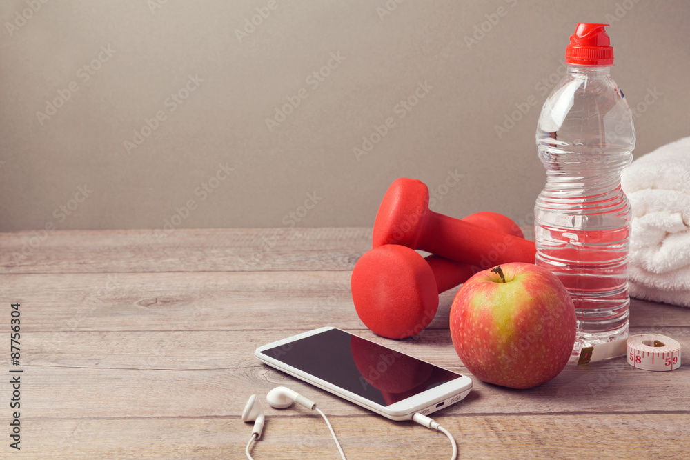 Wall mural Fitness background with bottle of water, apple and smartphone