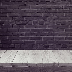 Empty wooden board background over black brick wall