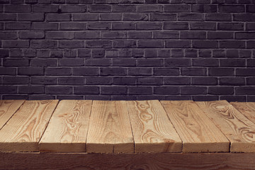 Wooden board background over black brick wall