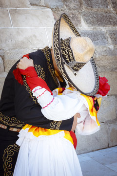 Pareja de novios con traje tradicional mexicano. Pareja besándose. Pareja tapados con sombrero demostrándose amor.